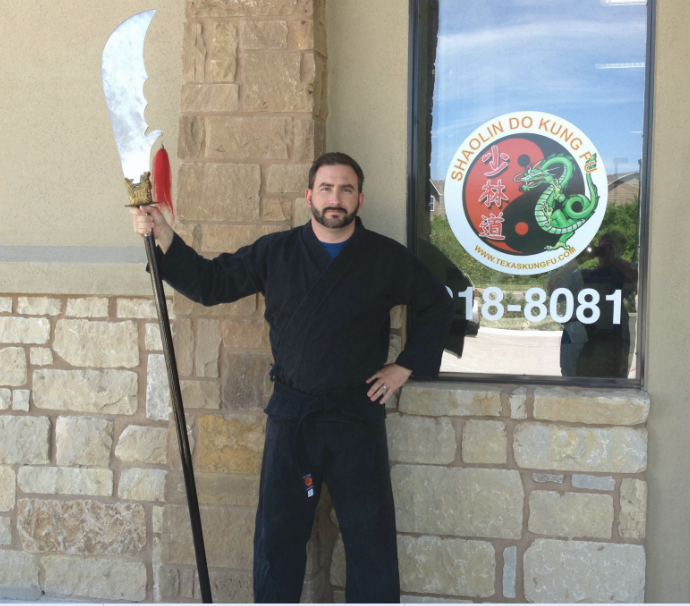 Donald in a martial arts uniform (gi), holding a Kwan Dao (giant sword affixed to a long pole)