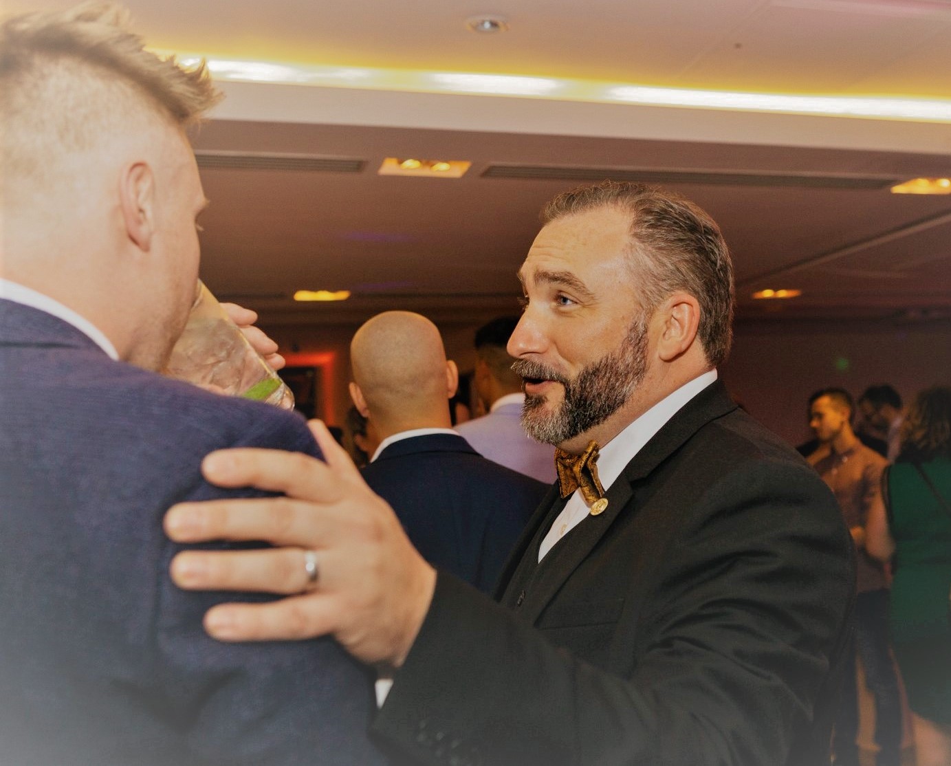 Donald Edwards with his hand on a friend's shoulder while engaging in small talk